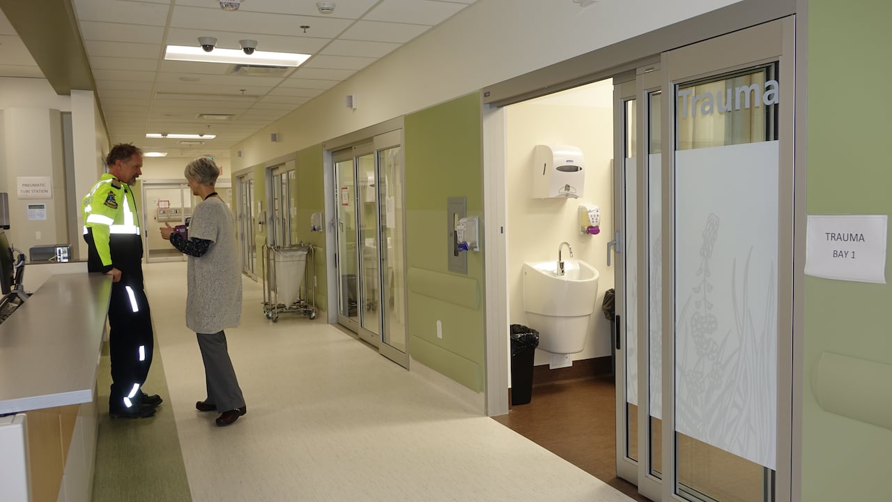 Hallway with two people standing. On the sides are rooms.