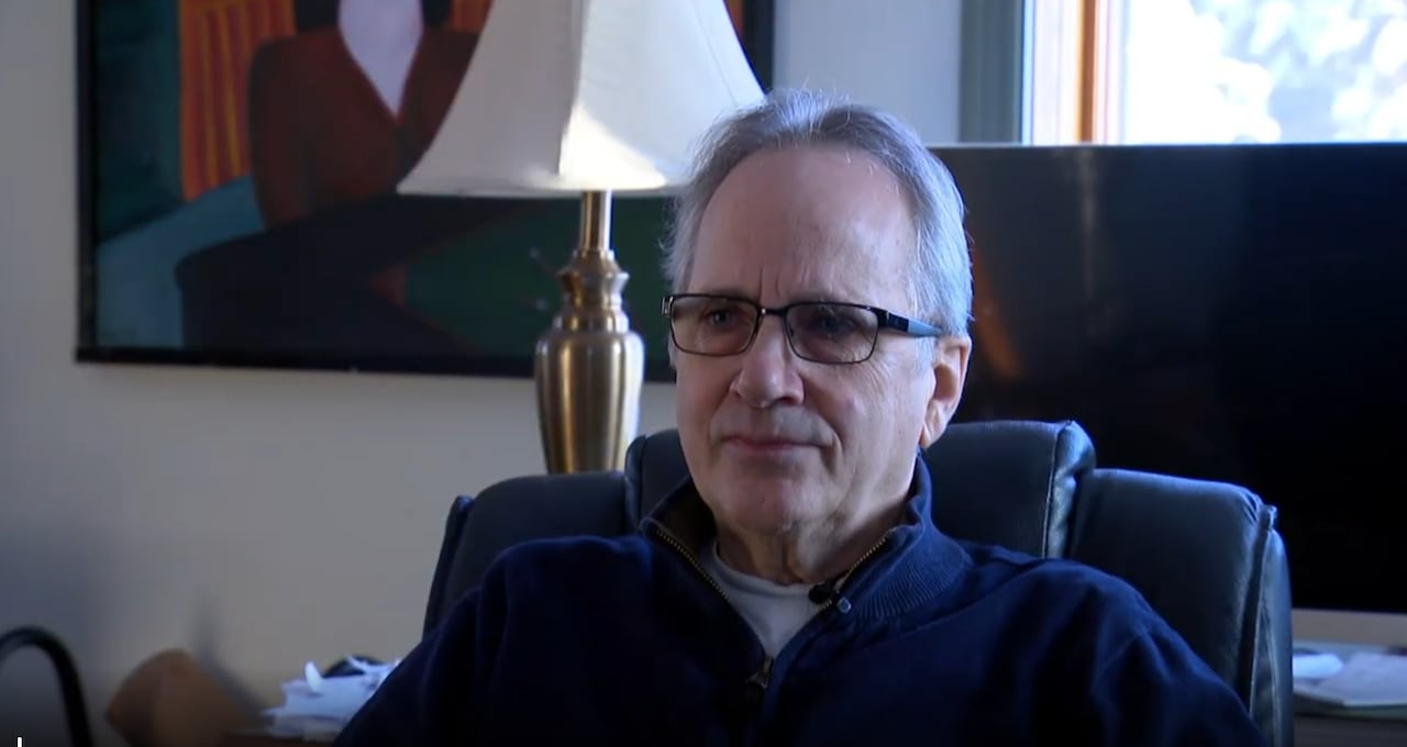 man in glasses sitting in a computer chair