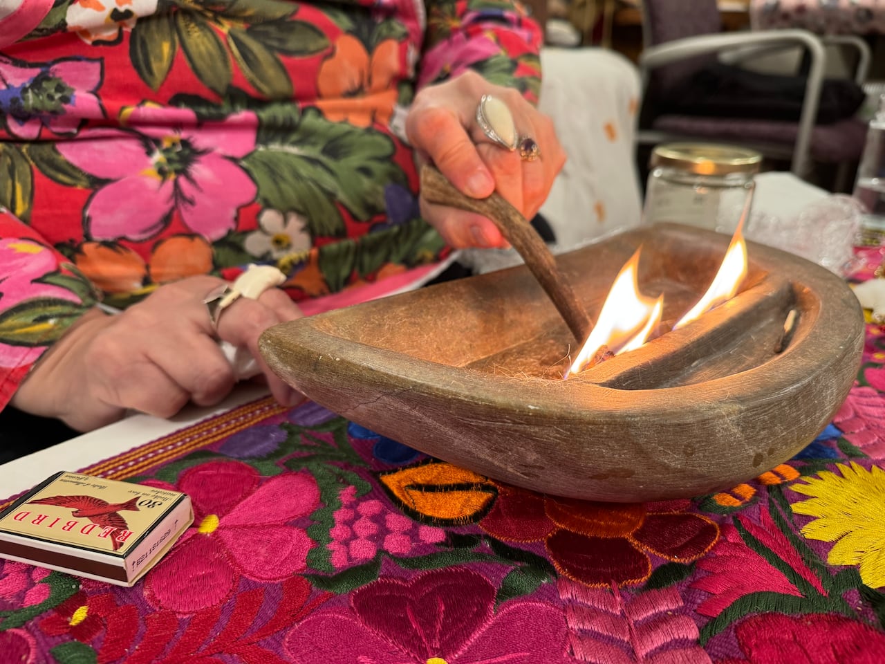 woman lights a fire in soapstone bowl