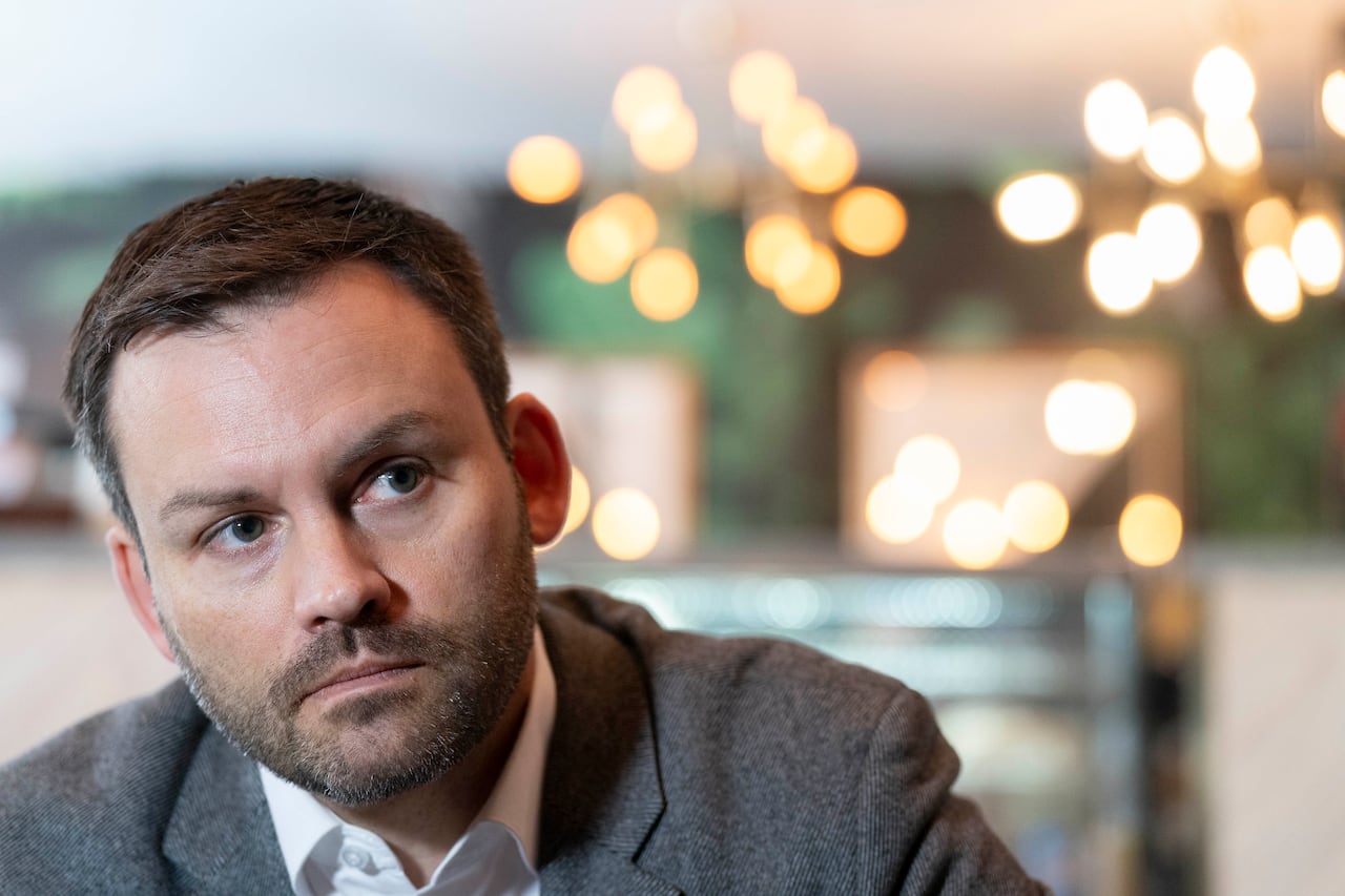 Young man gazes pensively.