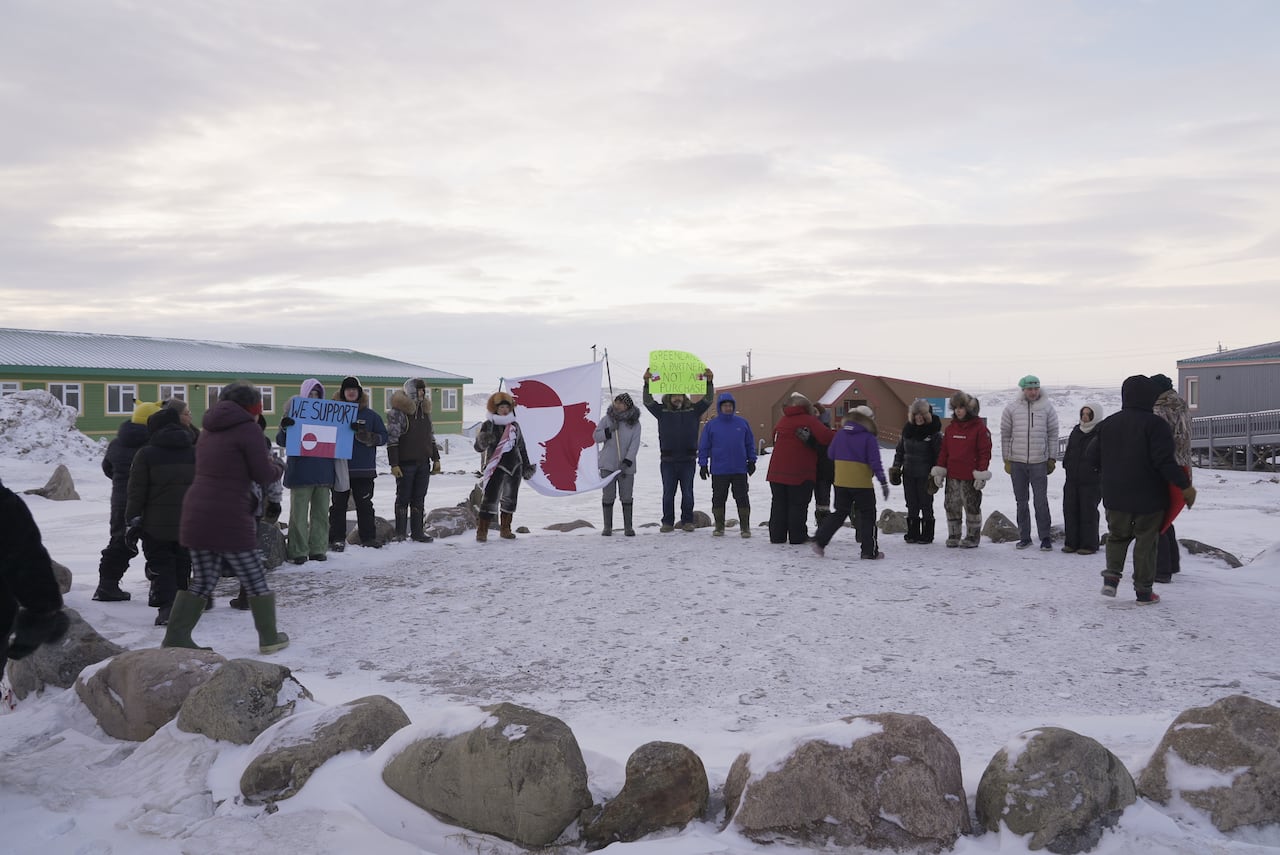 People standing in a half circle together carrying signs 