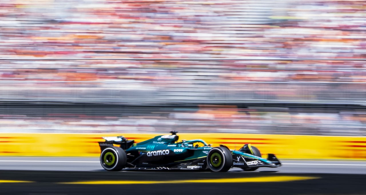An Aston Martin F1 car in front of a blurred background