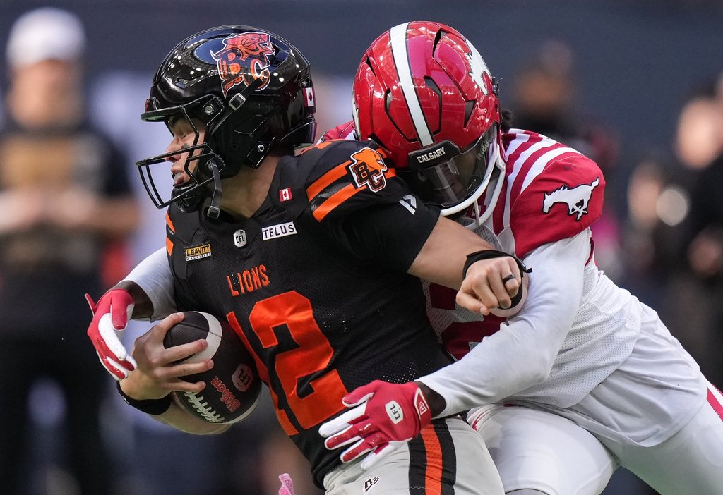 B.C. Lions quarterback Nathan Rourke, front left, is sacked by Calgary Stampeders