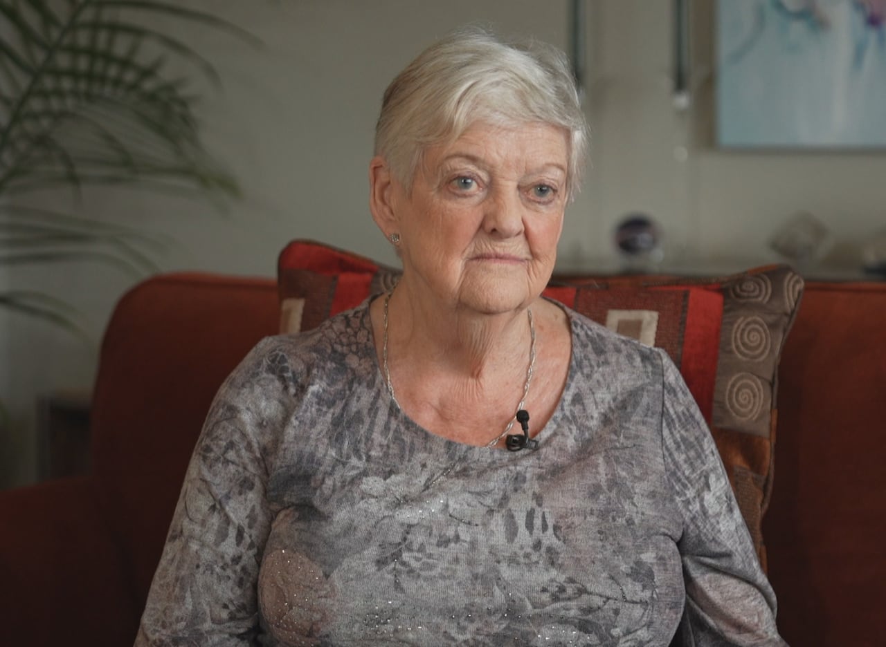 A white woman with short grey hair looks sad.