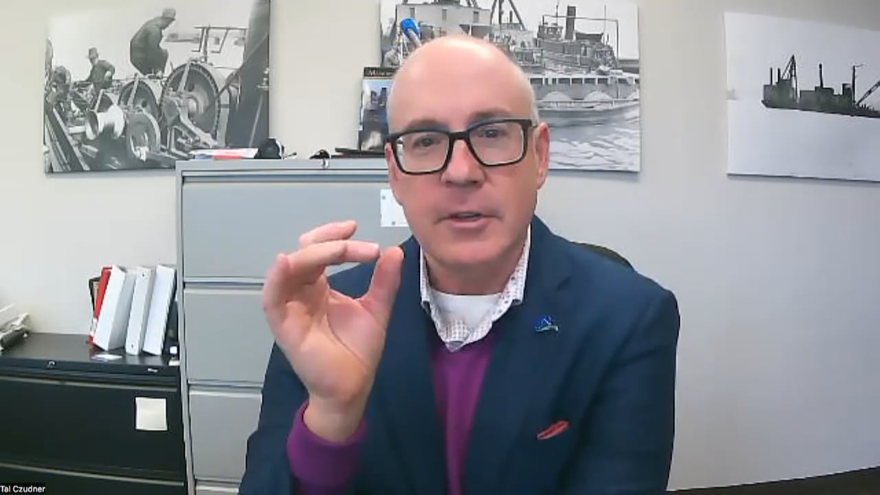 A man with glasses being interviewed via Zoom.