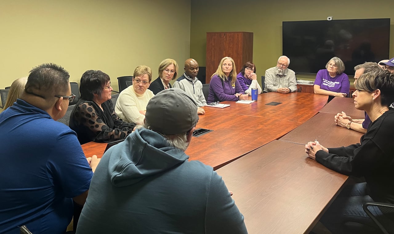 People sit around a board table.