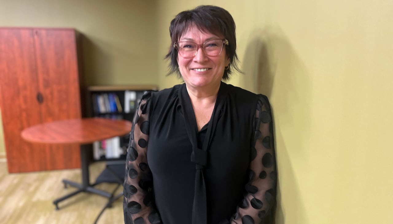 A woman in a black shirt smiles.