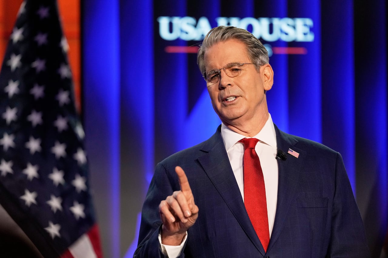 person in blue suit points up and away. 