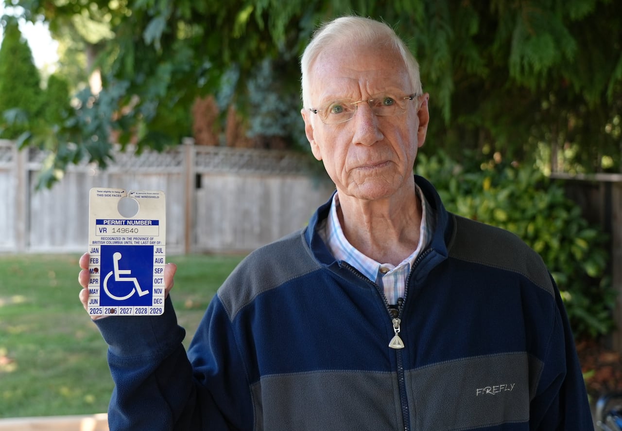 Man holding up sign with a wheelchair symbol