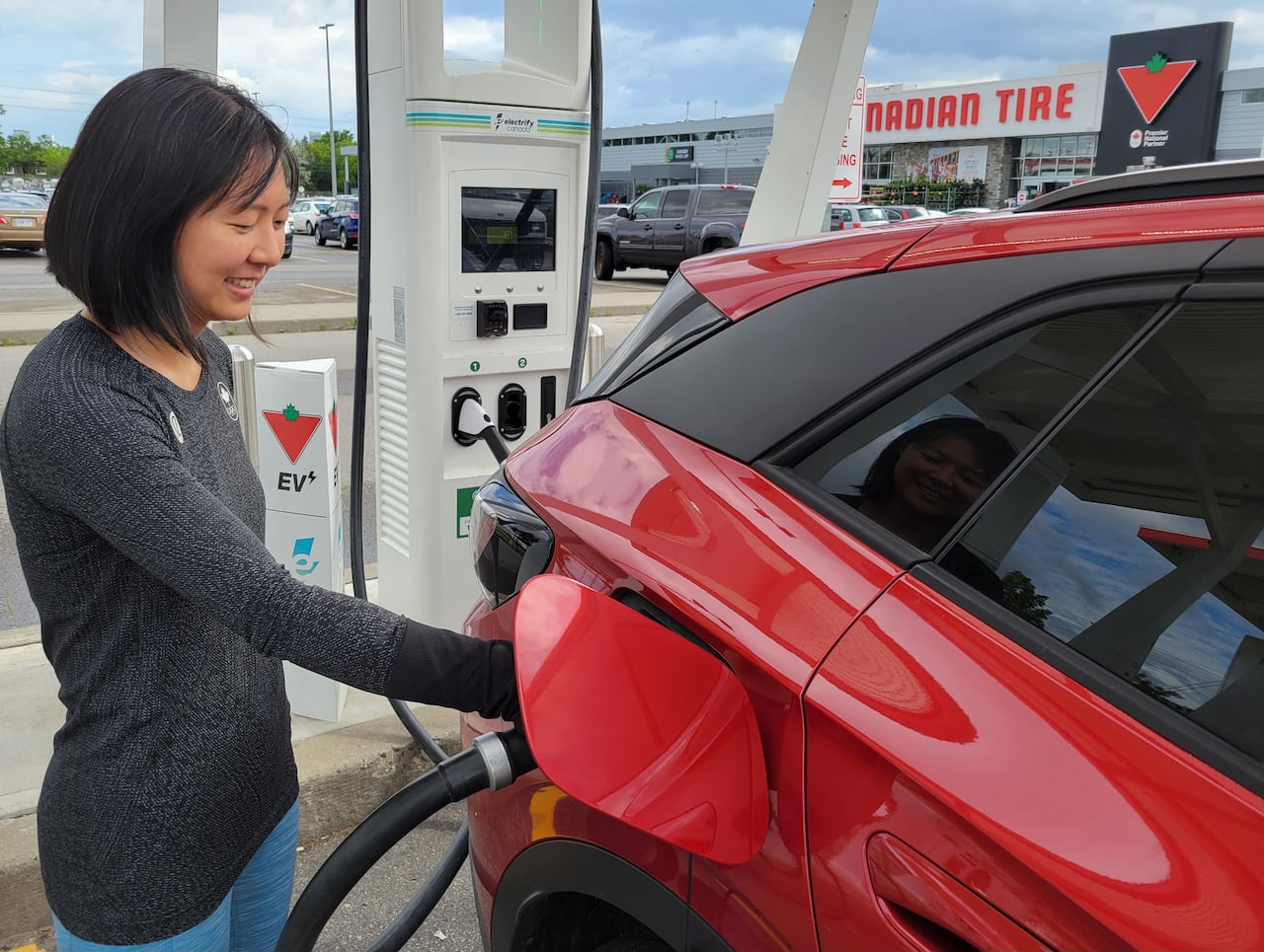 woman charges red car at Canadian Tire