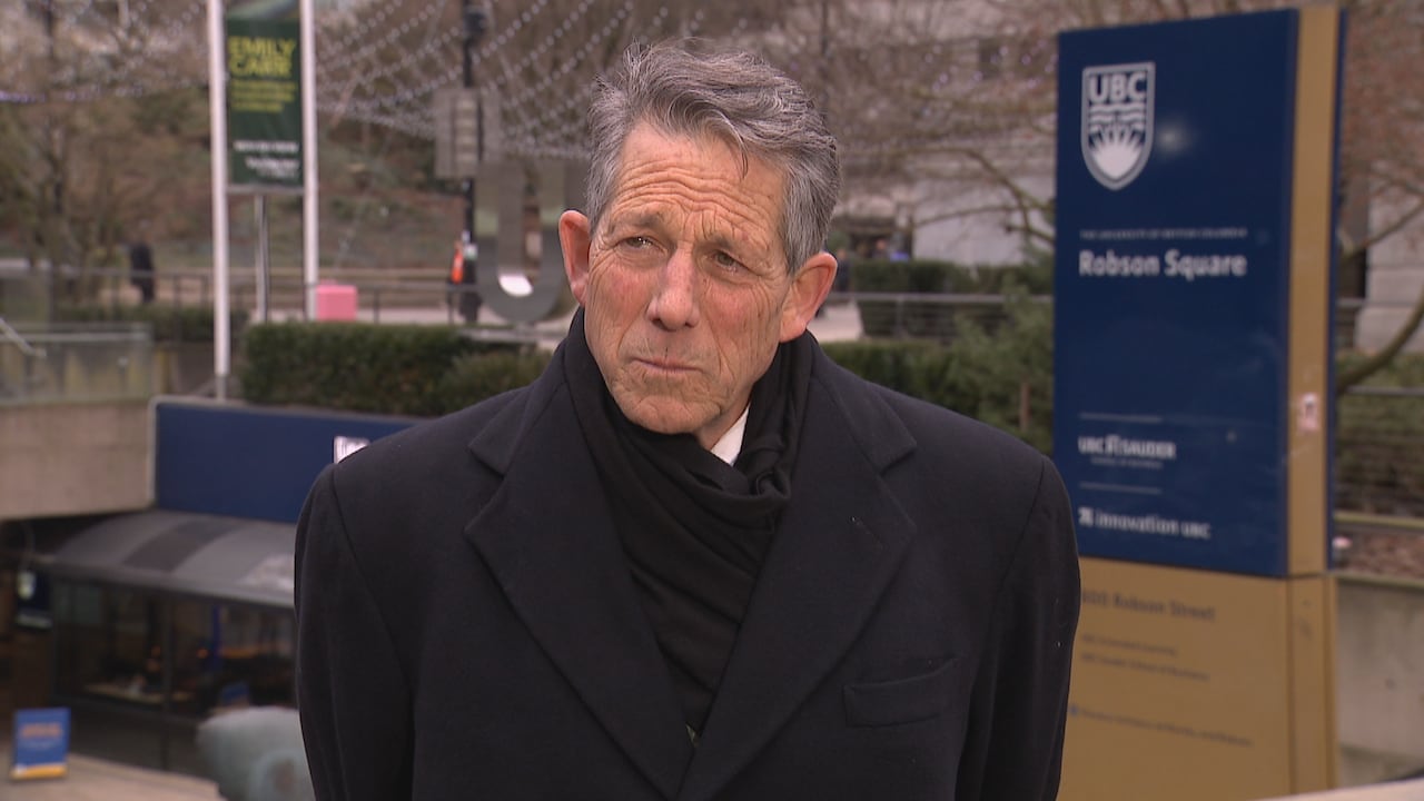 A man in a black winter jacket speaks