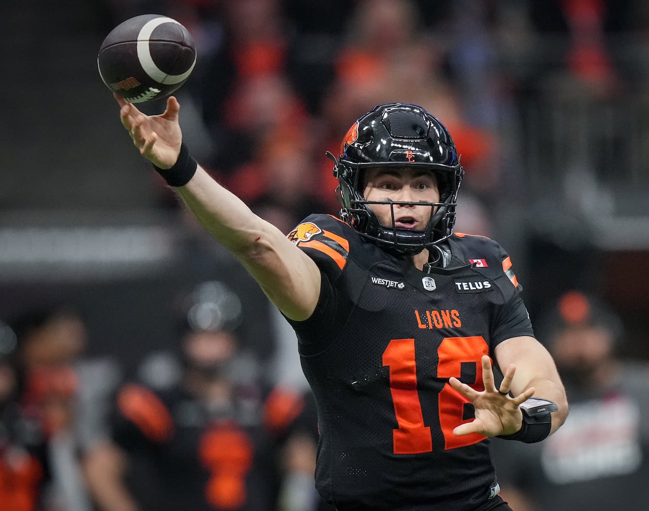 A Canadian football player throws the ball.