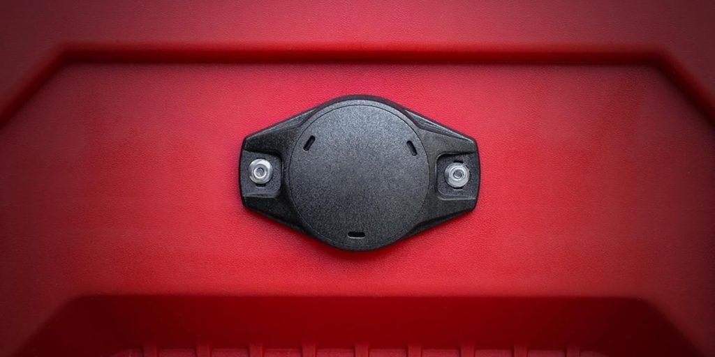 A black round object on a red plastic surface