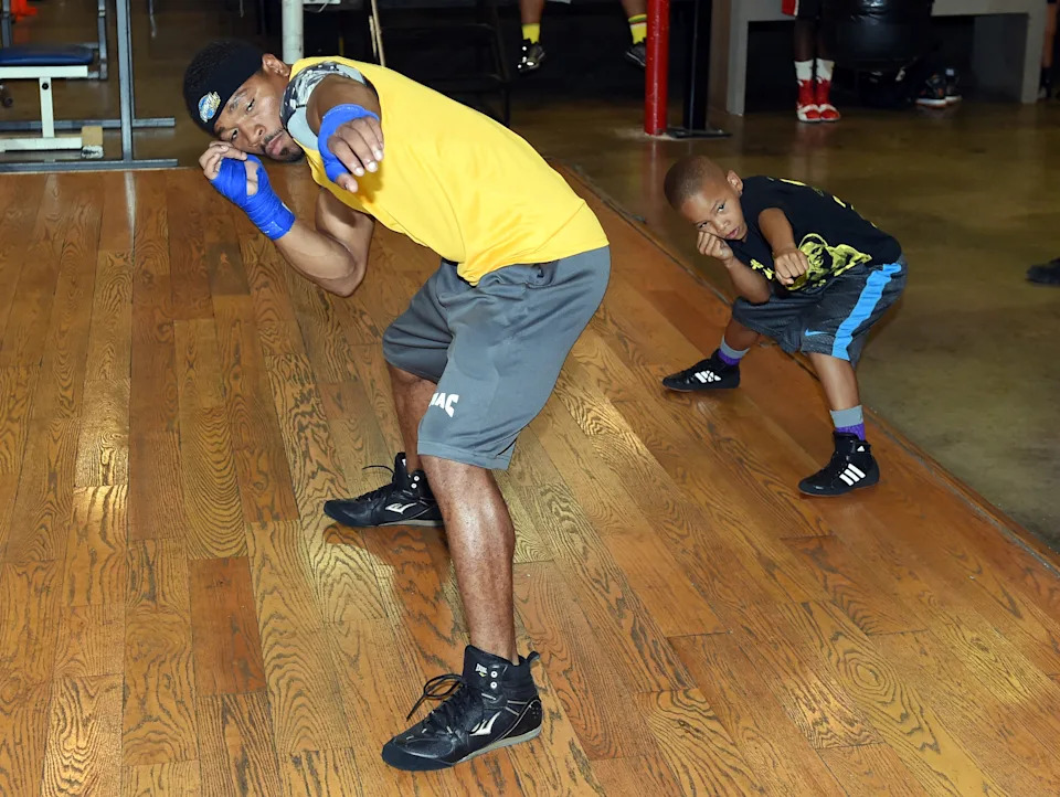 LAS VEGAS, NV - AUGUST 06:  IBF welterweight champion Shawn Porter (L) and Curmel Moton, 8, go through a drill during a media workout at Barry's Gym on August 6, 2014 in Las Vegas, Nevada. Porter will defend his title against Kell Brook in Carson, California on August 16.  (Photo by Ethan Miller/Getty Images)