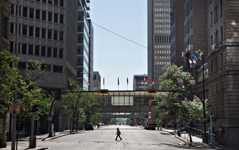 A woman crosses an empty downtown street in Calgary, Alberta