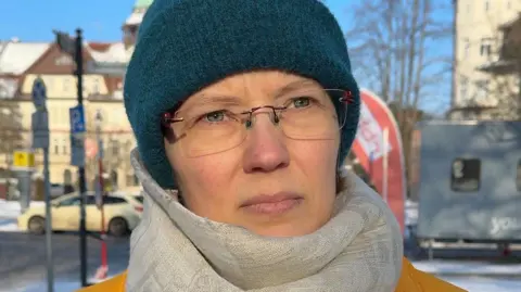 BBC Lena, wearing a scarf and a turquoise hat