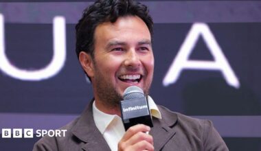 Sergio Perez speaking into a microphone at a Cadillac news conference in 2025