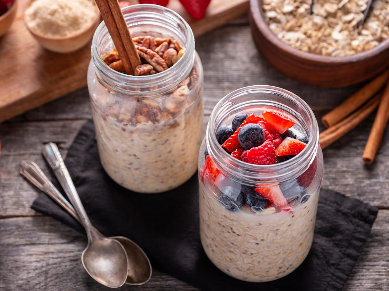 an arrangement of overnight oats with berries, nuts, seeds, honey, and cinnamon