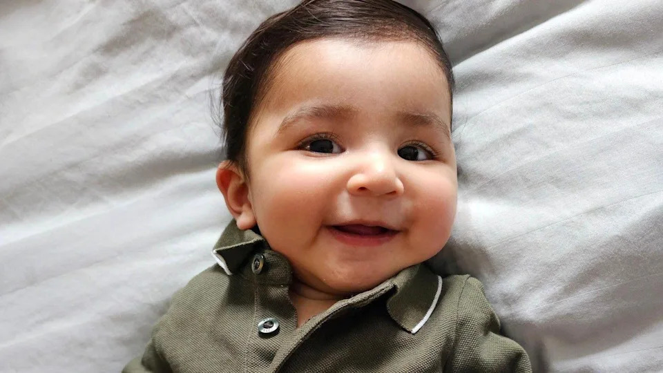 A photo of Aarav lying on a white sheet.