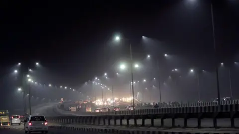 NurPhoto via Getty Images Cars driving through a highway as toxic smog covers the capital's skyline and air quality deteriorates further in the national capital after Dussehra celebrations, on October 28, 2020 in New Delhi, India.