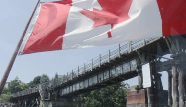 A Canada flag aboard a Victoria waterway tour boat frames the Selkirk Trestle. Canada Day festivities in the provincial capital will see an added influx of funds, still hitting only half of the $400,000 spent in previous years. (Christine van Reeuwk/Victoria News)