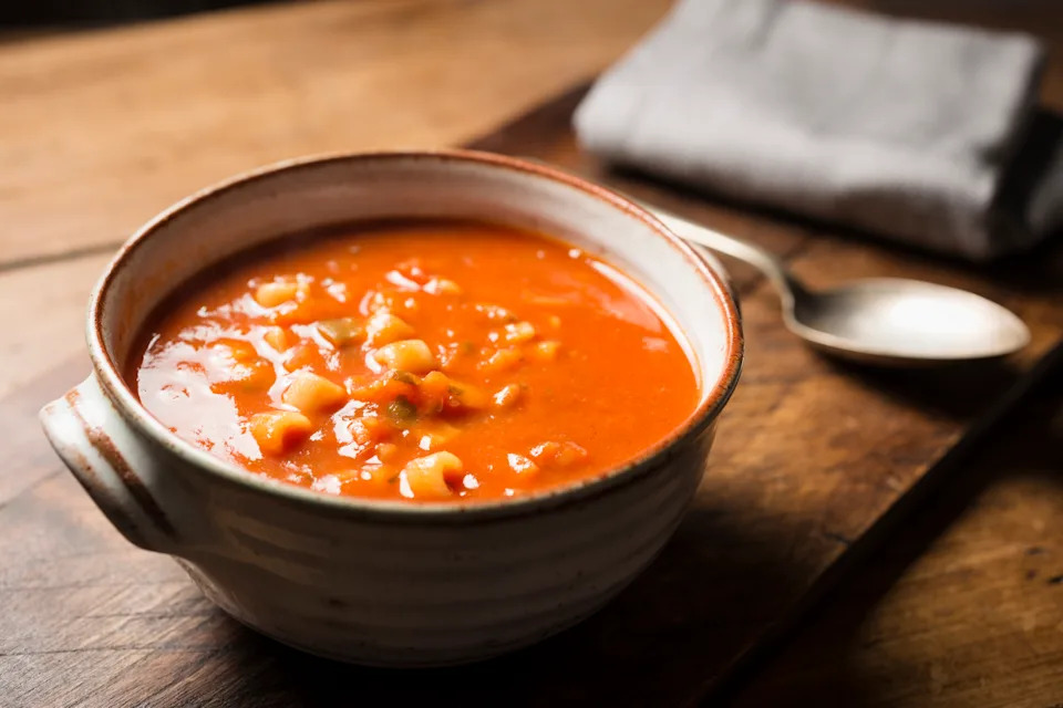 Overhead shot of a bowl of minestrone soup on a wooden table