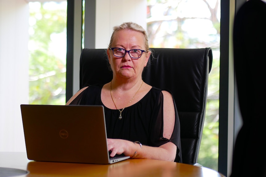 Woman sitting at desk with laptop.