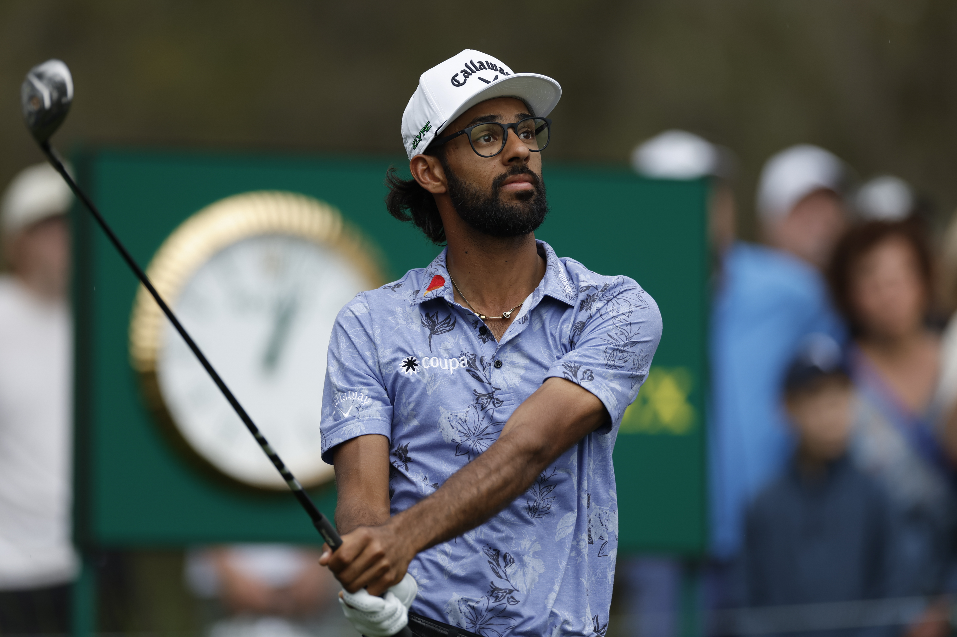 Akshay Bhatia strikes his tee shot and watches its flight
