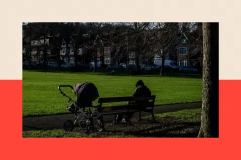 AFP via Getty Images A parent sits with a pram in a park