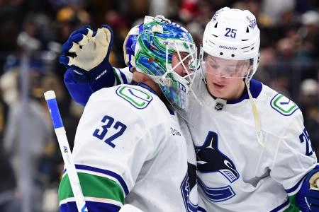 Dec 20, 2025; Boston, Massachusetts, USA; Vancouver Canucks defenseman Elias Pettersson (25) congratulates goaltender Kevin Lankinen (32) after a shootout win over the Boston Bruins at TD Garden.