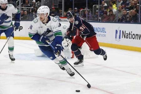 Jan 15, 2026; Columbus, Ohio, USA; Vancouver Canucks center Elias Pettersson (40) looks to pass as Columbus Blue Jackets center Kent Johnson (91) trails the play during the second period at Nationwide Arena.