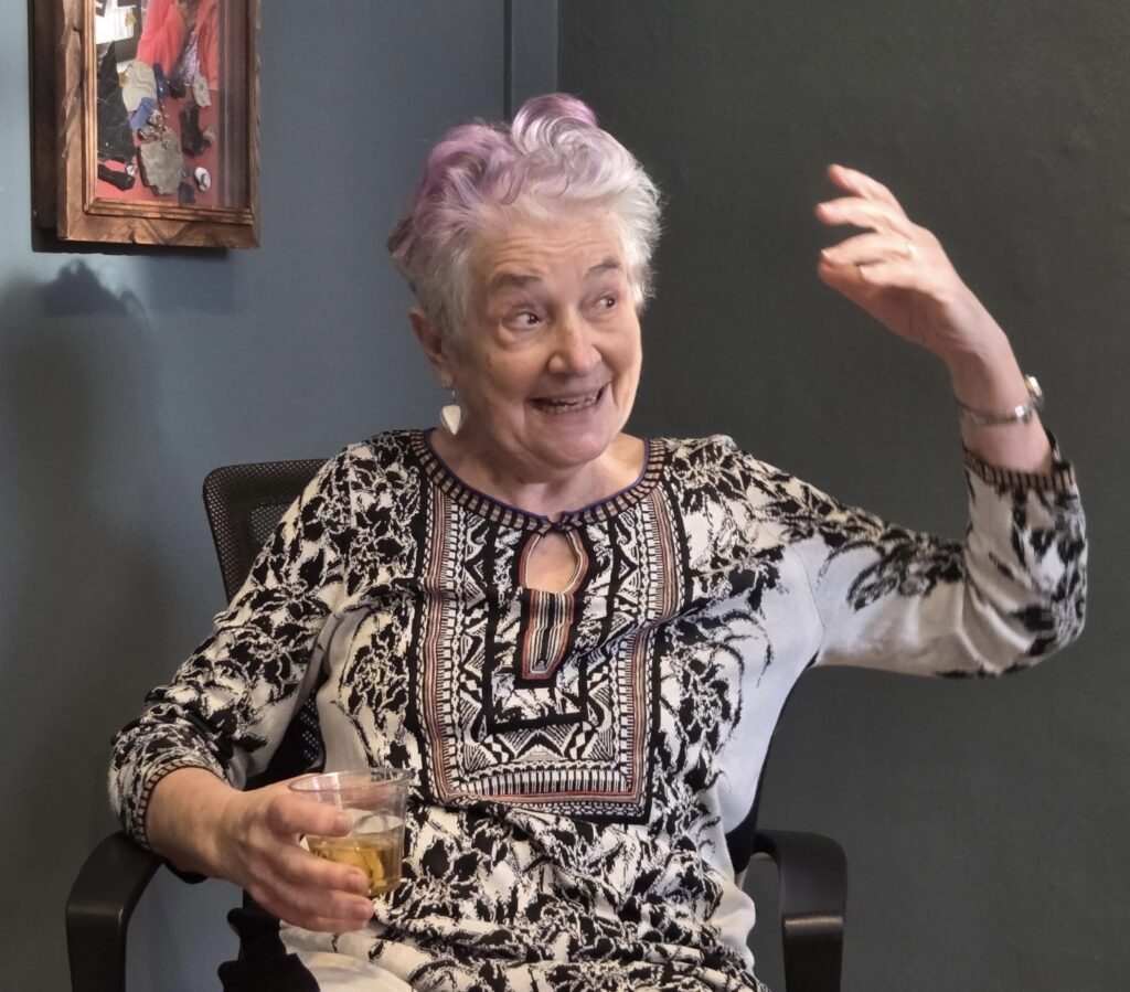 older woman in print blouse, gesturing