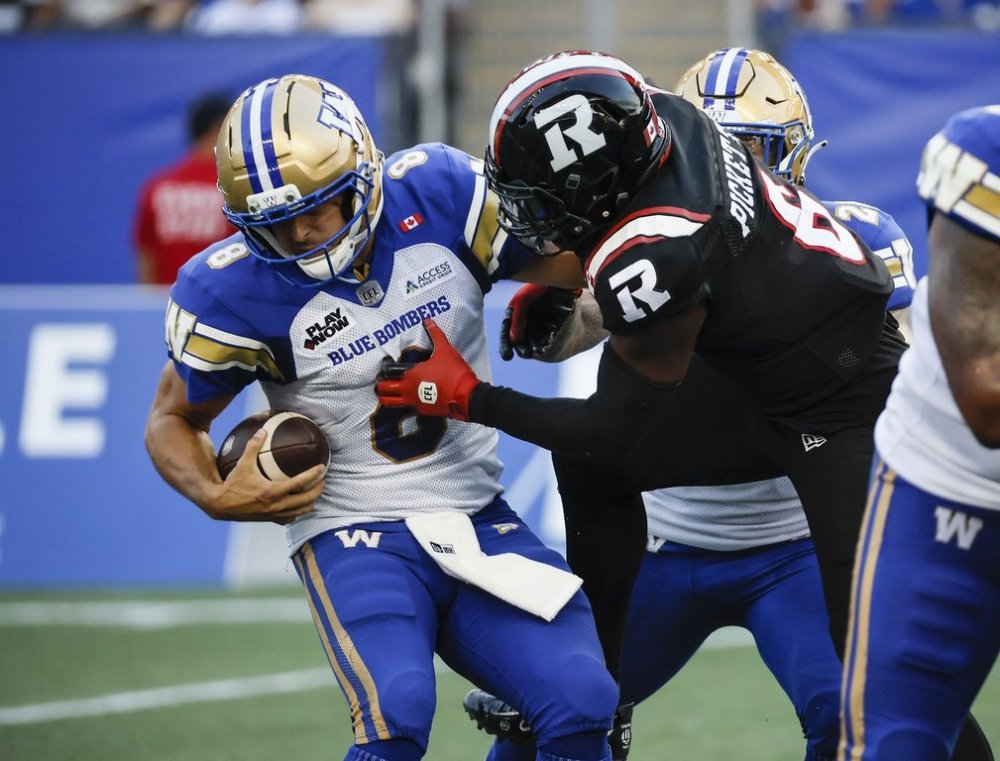 Winnipeg Blue Bombers quarterback Zach Collaros (8) gets pressure from Ottawa Redblacks' Adarius Pickett (6) during first half CFL action in Winnipeg Thursday, August 14, 2025. THE CANADIAN PRESS/John Woods