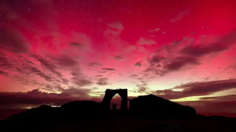 MATTHEW MUTTOCK The Silhouette of Gronez Castle in the  red Northern Lights