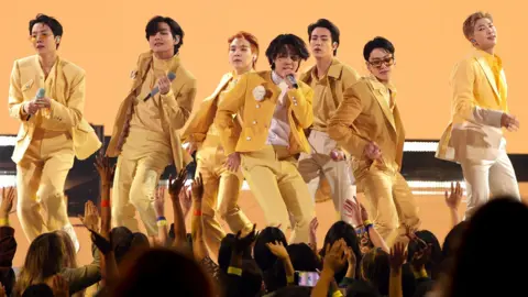 Getty Images BTS on stage in matching yellow suits