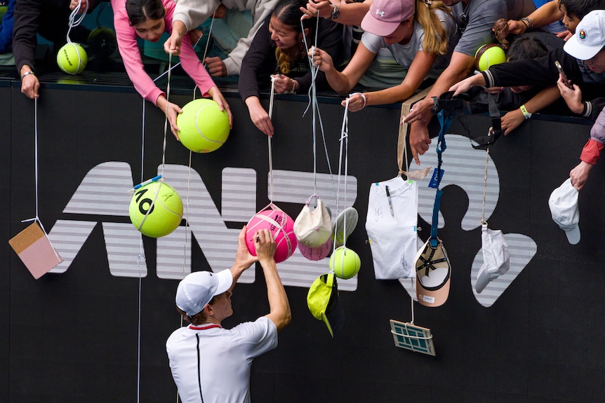 Jannik Sinner applauds the crowd at a tennis match