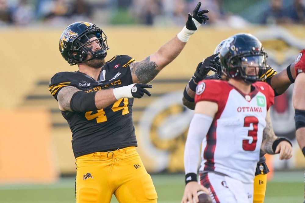 Hamilton Tiger-Cats' Casey Sayles, left, celebrates after sacking Ottawa quarterback Dru Brown (3) during first half CFL action in Hamilton, Ont. on Saturday, July 12, 2025. THE CANADIAN PRESS/ Geoff Robins