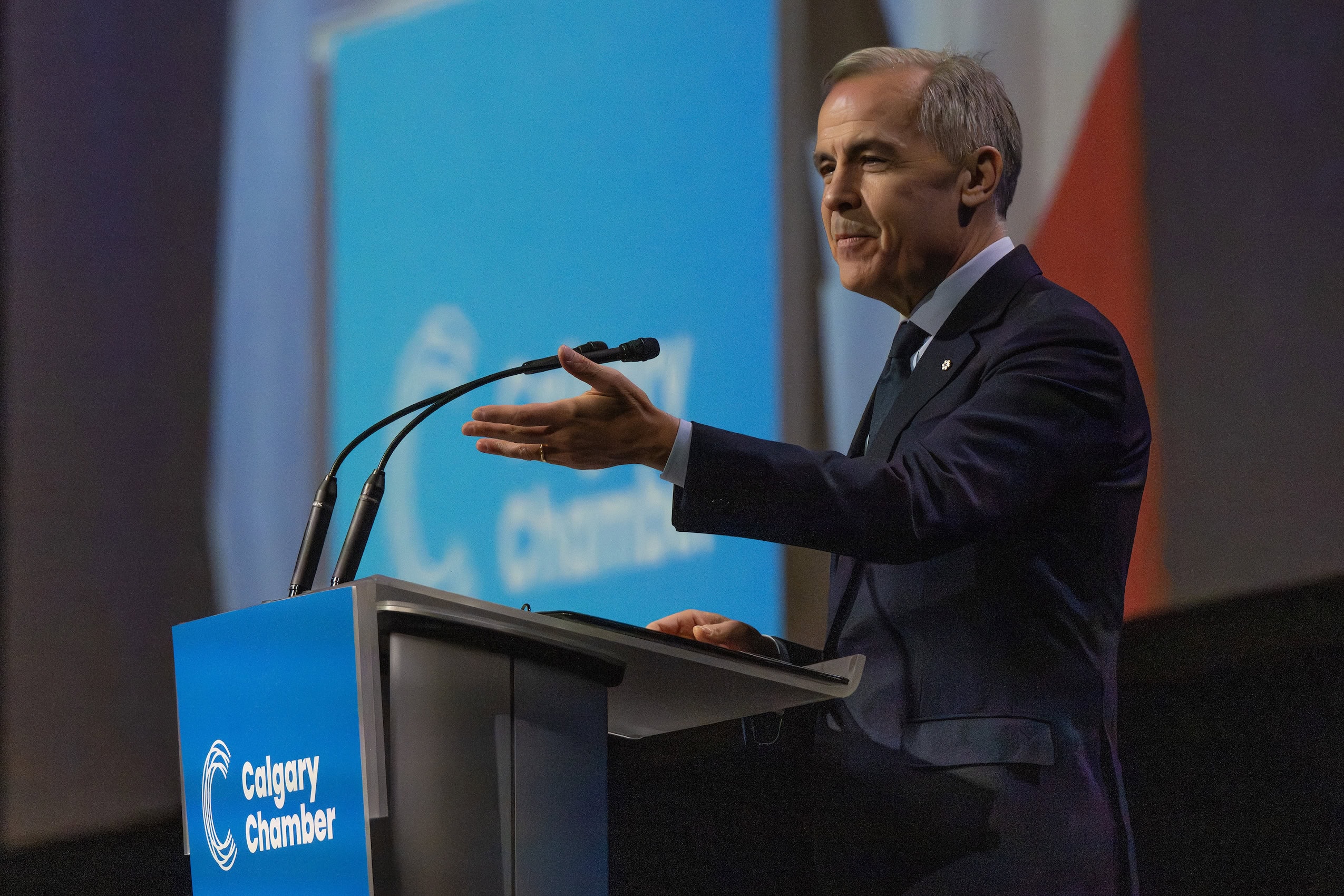 Mark Carney gesturing to a crowd at a podium.