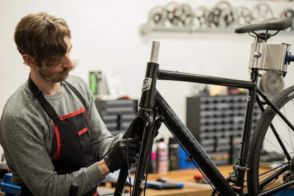 Will Soffe fitting a fork on a road bike in the workshop.