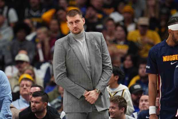 Injured Denver Nuggets center Nikola Jokic (15) looks on from the bench in the second half of an NBA basketball game Friday, Jan. 9, 2026, in Denver. (AP Photo/David Zalubowski)