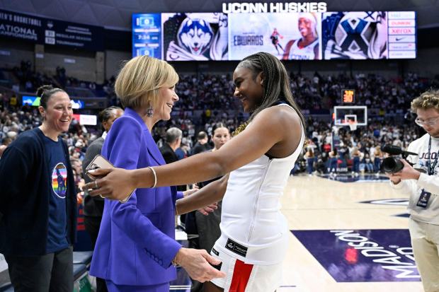 Former UConn player and WNBA player Aaliyah Edwards, right, embraces associate head coach Chris Dailey, left, during a pregame ceremony adding Edwards to the Huskies of Honor before an NCAA college basketball game against Xavier, Wednesday, Jan. 28, 2026, in Storrs, Conn. (AP Photo/Jessica Hill)