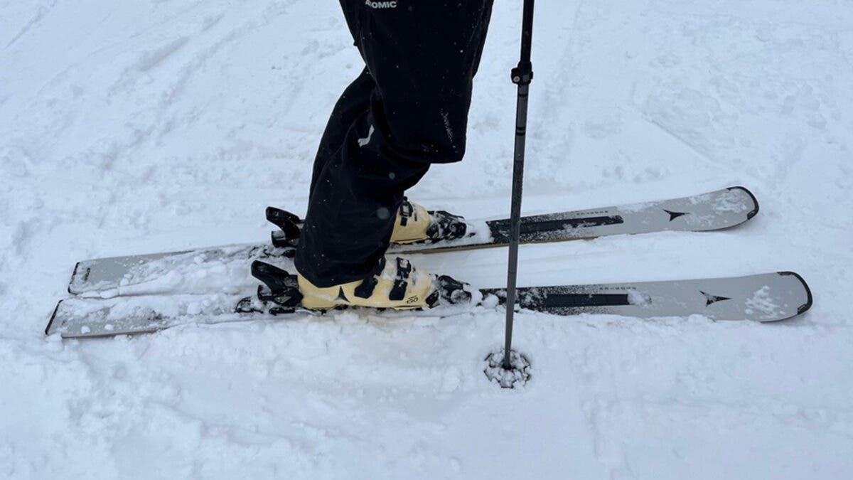 Closeup of skier clicked into 2027 Atomic Cloud Q frontside skis on snow