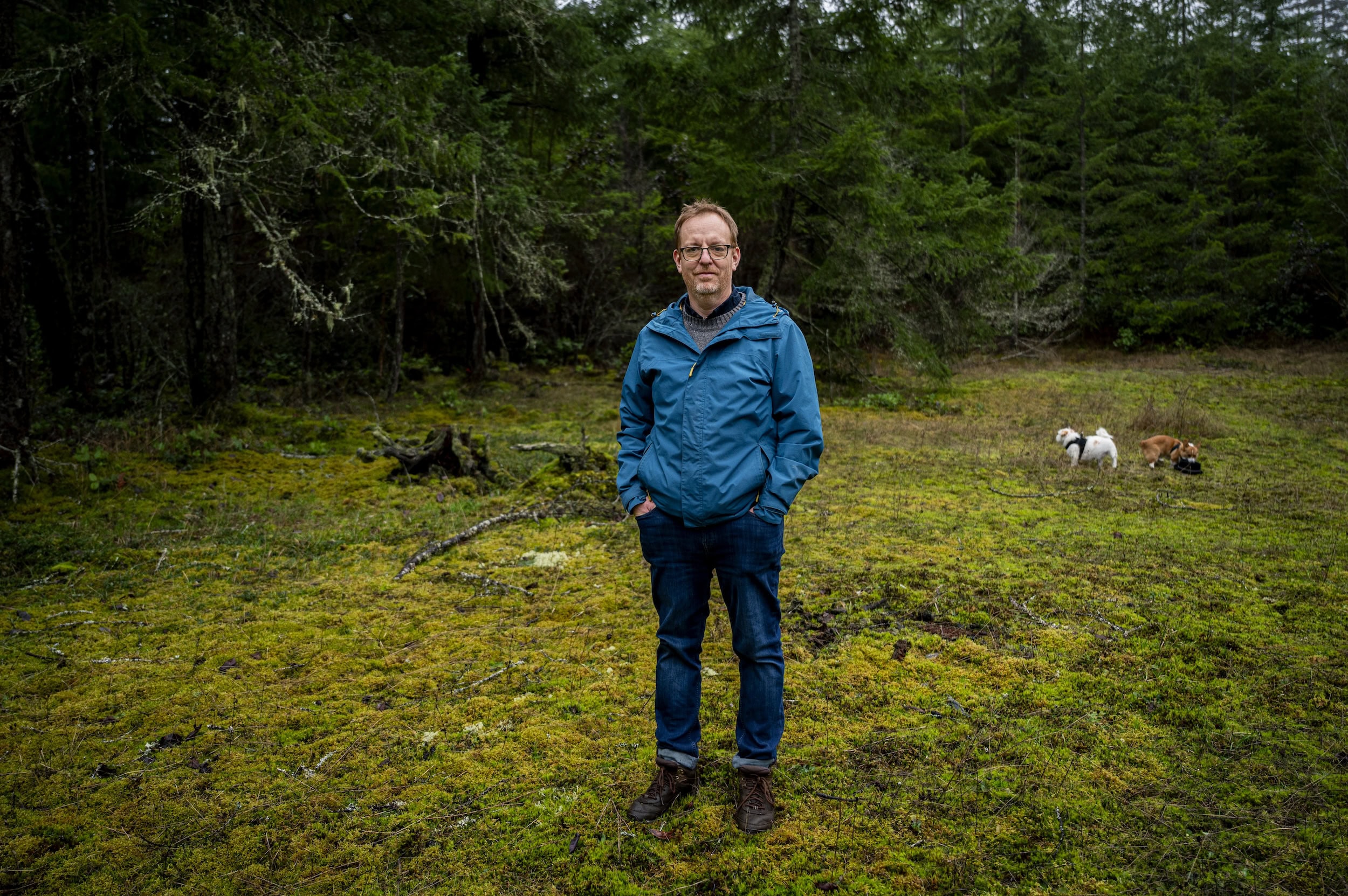 Damien Joly, CEO of the Canadian Wildlife Health Cooperative, stands in a grassy area at the edge of a forest.