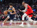 Denver Nuggets guard Jamal Murray drives around Toronto Raptors forward/guard RJ Barrett, right, during first half NBA action in Toronto on Wednesday, Dec. 31, 2025.  