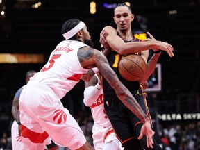 Zaccharie Risacher, right, of the Hawks, loses the ball as he drives against the Raptors' Brandon Ingram, left, during second quarter Emirates NBA Cup action at State Farm Arena in Atlanta, Nov. 7, 2025.