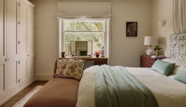 neutral london bedroom designed by Emma Ainscough with a wall of wardrobes and a canopy bed