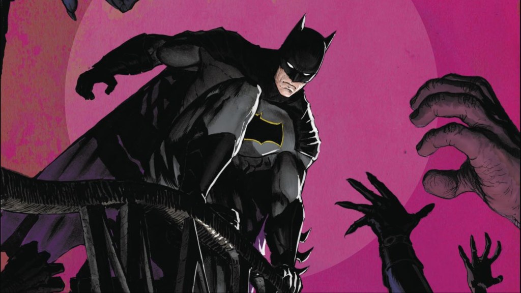 Batman perched on the gates of Arkham Asylum while hands reach towards him