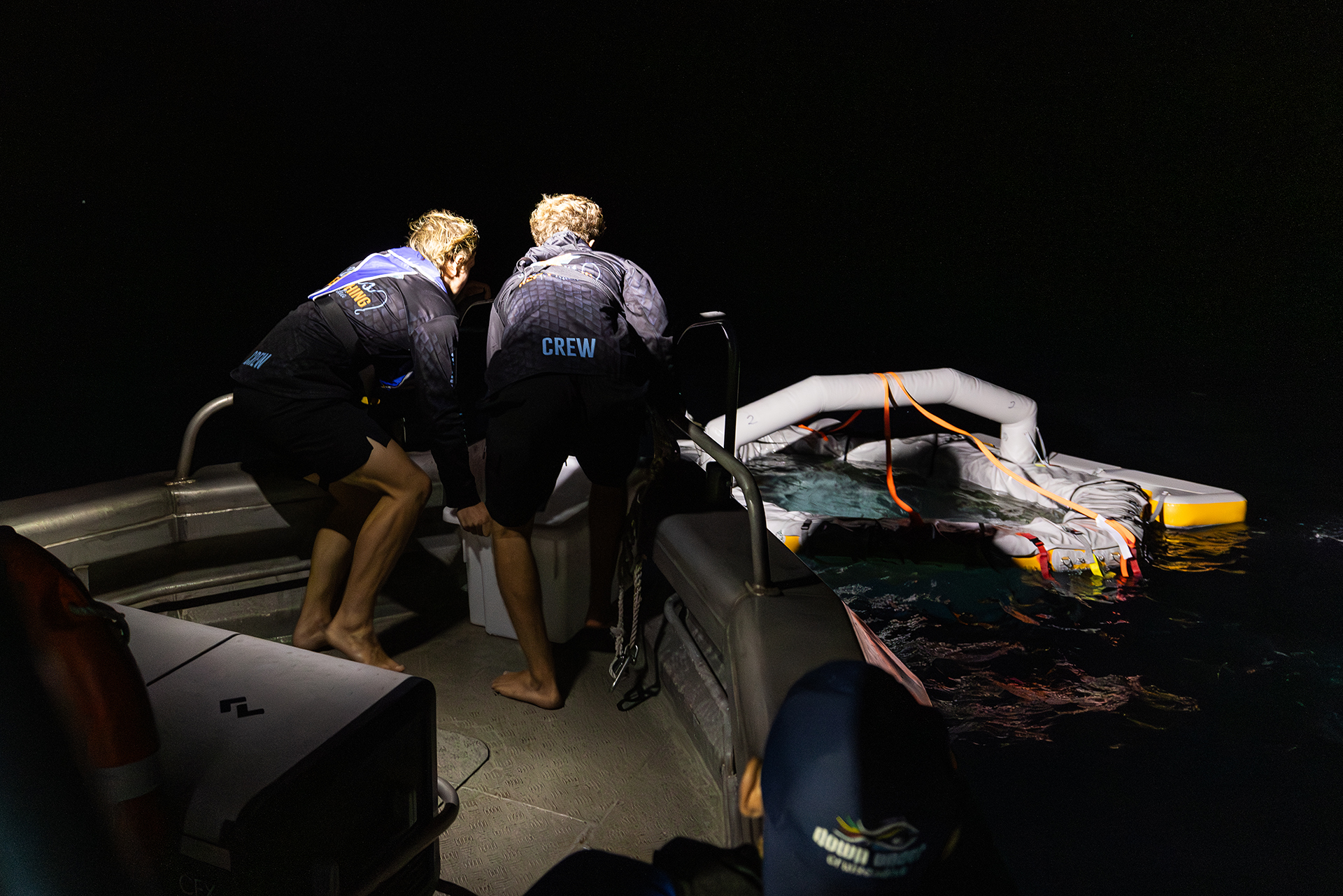 Two people in diving gear dump a bucket of spawn