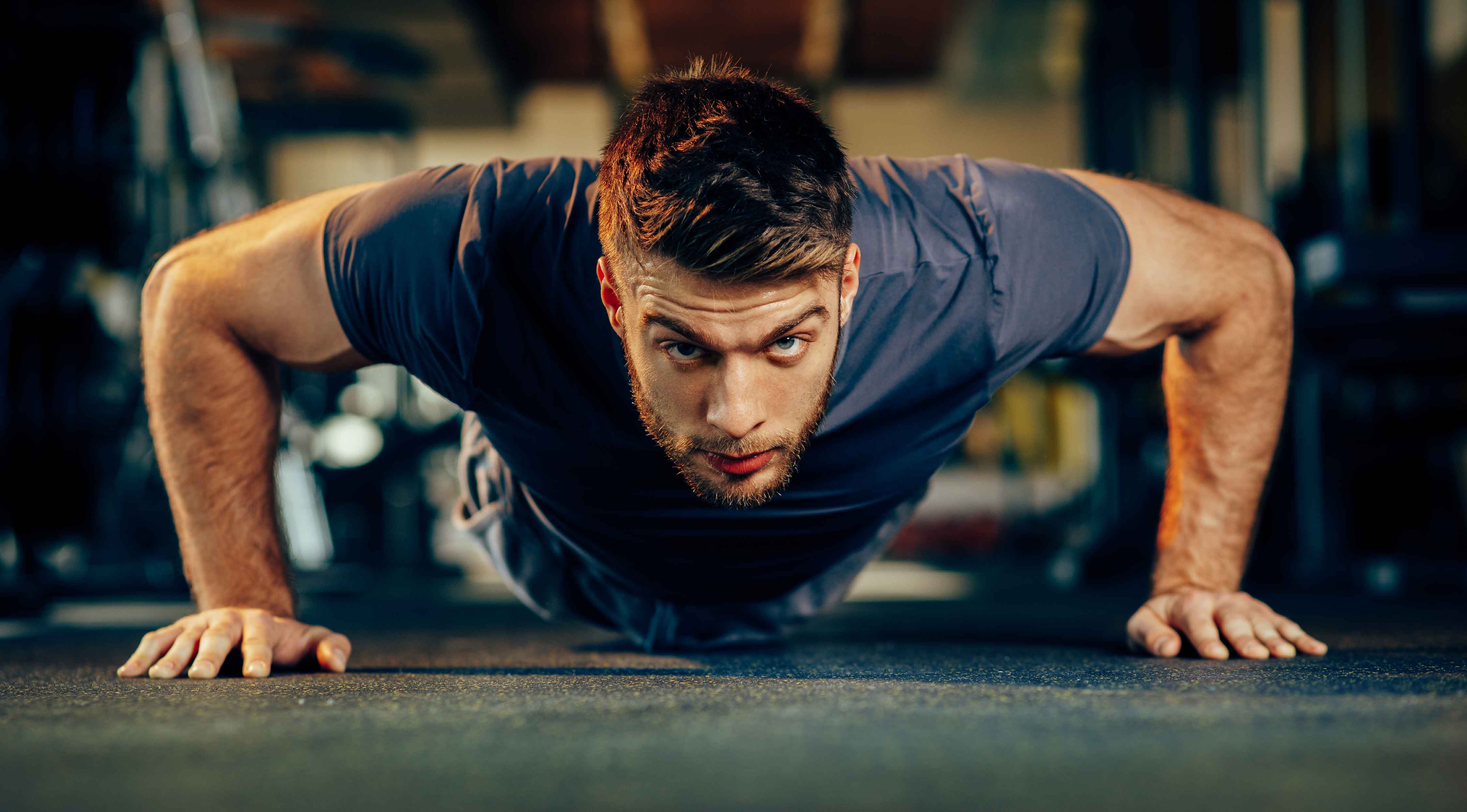 bearded man doing chest workout with a bodyweight pushup exercise