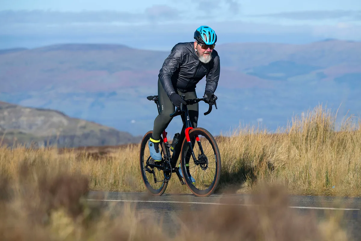 Male cyclist in black top riding the Ribble AllRoad SL R Hero road bike